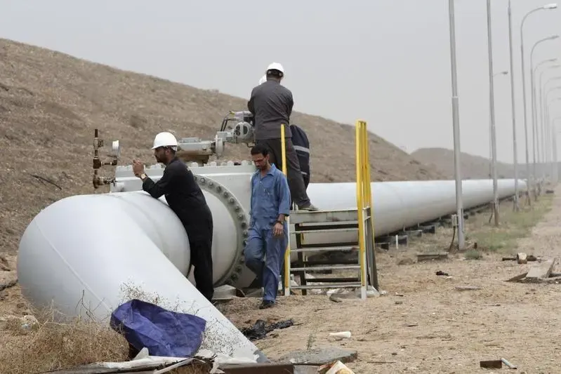 Image used for illustrative purpose. Workers adjust a valve of an oil pipe at Al Tuba oil field in Basra, southeast of Baghdad .-1